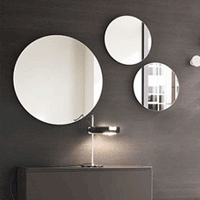 a wall with mulitple circular frameless mirrors installed