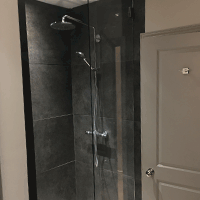 a walk in shower with a glass panel return