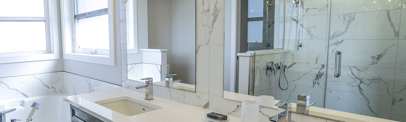 wide shot of a double vanity area with two silver mirrors fitted to the wall